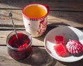 Sweet snack with cranberry marshmallow and marmalade, tea in a large ceramic mug and a glass jar with cherry jam and a Royalty Free Stock Photo