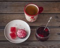 A sweet snack with cranberry marshmallows and marmalade, tea in a large ceramic mug and a glass jar with cherry jam and Royalty Free Stock Photo