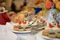 Delicious sweet snacks small cakes with cream and chocolate on the banquet table Royalty Free Stock Photo