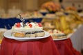 Delicious sweet snacks small cakes with cream and chocolate on the banquet table