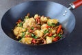 Sweet and sour beef stir fried in the wok with cauliflower and vegetables on a grey abstract background. Oriental dish