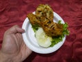 Sweet and sour fried chicken in a white container with cucumber slices and green lettuce Royalty Free Stock Photo