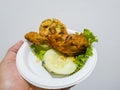 Sweet and sour fried chicken in a white container with cucumber slices and green lettuce Royalty Free Stock Photo