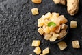 Sweet and spicy candied ginger in black bowl on dark stone background. Top view