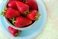 Sweet strawberries in a blue ceramic Cup with a saucer, close up Royalty Free Stock Photo