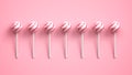 Sweet striped pink and white lollipops arranged in row on bright pink background
