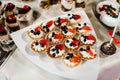 Sweet table. A plate of cakes and muffins with cream with berries. Table with sweets, candy, buffet. Dessert table for a party Royalty Free Stock Photo