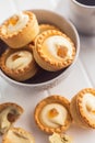 Sweet tarlets. Tasty mini tarts. Mini pie with cream in bowl on kitchen table