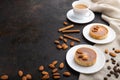 Sweet tartlets with almonds and caramel cream with cup of coffee on a black concrete background. Side view, copy space Royalty Free Stock Photo