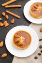 Sweet tartlets with almonds and caramel cream with cup of coffee on a black concrete background. top view, selective focus Royalty Free Stock Photo