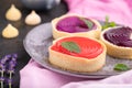 Sweet tartlets with jelly and milk cream with cup of coffee on a black concrete background. Side view, selective focus Royalty Free Stock Photo