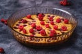 Sweet tasty pie with jellied and fresh raspberry fruits in baking dish, dark stone concrete background Royalty Free Stock Photo