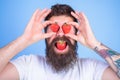 Sweet temptation. Man in love with strawberry. Hipster with beard eats strawberry and hold berries as eyeglasses Royalty Free Stock Photo
