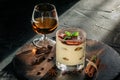 Sweet tiramisu in glass with a glass of cognac