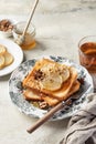 Sweet toast with cream cheese, caramelized pear, nuts and honey with cup of tea for breakfast on textured background Royalty Free Stock Photo