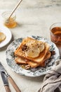 Sweet toast with cream cheese, caramelized pear, nuts and honey with cup of tea for breakfast on textured background Royalty Free Stock Photo