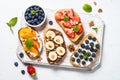 Sweet toast assortment with fresh fruit and berries on white. Royalty Free Stock Photo