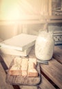 Sweet toast with milk in jar on wooden table with books