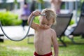 Sweet toddler boy, taking a shower on outdoor showers on the beach