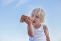 Sweet toddler child, eating pizza on the beach, having fun, smiling happily, kid enjoying dinner Royalty Free Stock Photo