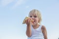 Sweet toddler child, eating pizza on the beach, having fun, smiling happily, kid enjoying dinner Royalty Free Stock Photo