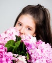 Sweet toddler girl with floral on and flowers bunch in hands. Portrait of a smiling little girl holding flowers. Cute