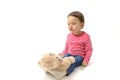 Sweet toddler girl playing with her teddy bear putting him on feet to sleep