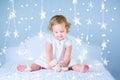 Sweet toddler girl playing with her toy bear in a white bedroom between