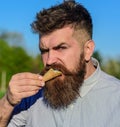 Sweet tooth concept. Bearded man with ice cream cone. Man with beard and mustache on strict brutal face eats ice cream Royalty Free Stock Photo
