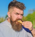 Sweet tooth concept. Bearded man with ice cream cone. Man with beard and mustache on strict brutal face eats ice cream Royalty Free Stock Photo