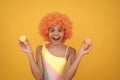 sweet tooth. funny kid in clown wig hold french macaron. amazed child wear swimsuit. Royalty Free Stock Photo