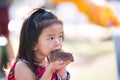A sweet-toothed child eats chocolate. Adorable kid girl enjoy eating with picnic snack in a summer holiday. Baby aged 4-5 years