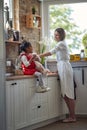 A Sweet Trio: Mother, Daughter, and Teddy Bear Unite Over Muffins in the Kitchen