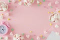 Flat lay photo of heart shaped saucers with candies and heart marshmallow, paper envelope, alarm clock