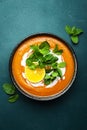 Sweet vegan pumpkin soup with coconut cream, orange and mint. Winter or autumn healthy vegetarian comfort food. Soup bowl on green