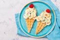 Sweet waffles with banana and strawberry in a shape of ice cream cone, meal for kids idea, top view Royalty Free Stock Photo