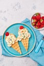 Sweet waffles with banana and strawberry in a shape of ice cream cone, meal for kids idea, top view Royalty Free Stock Photo