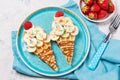 Sweet waffles with banana and strawberry in a shape of ice cream cone, meal for kids idea, top view Royalty Free Stock Photo