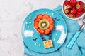 Sweet waffles with fruits in a shape of air balloon in the sky, meal for kids idea, top view Royalty Free Stock Photo