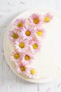 Sweet white buttercream cake with pink flowers on top