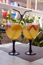 Sweet white sangria fruit in glass goblets on the table. Traditional spanish food. Two glasses on a table in a Spanish restaurant Royalty Free Stock Photo