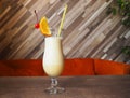 Sweet white and yellow cocktail with milk foam and with piece of orange and cherry Royalty Free Stock Photo