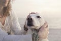 Sweet woman lovingly caresses her white dog