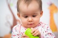 Sweet 1 year old baby girl portrait with rubber chew toy in her room Royalty Free Stock Photo