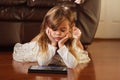 Sweet 4 year old girl in white, playing with iPad