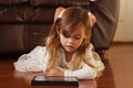 Sweet 4 year old girl in white, playing with iPad