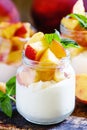 Sweet yogurt with peach and mint in glass jar, selective focus