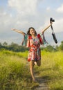 Sweet young Asian Chinese or Korean woman on her 20s posing happy and playful holding photo camera smiling happy in beautiful natu