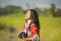 Sweet young Asian Chinese or Korean woman on her 20s taking picture with photo camera smiling happy in beautiful nature landscape Royalty Free Stock Photo