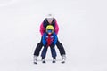 Sweet young boy and his mother, learning to ski on a mild ski slope in Austrian ski resort Royalty Free Stock Photo